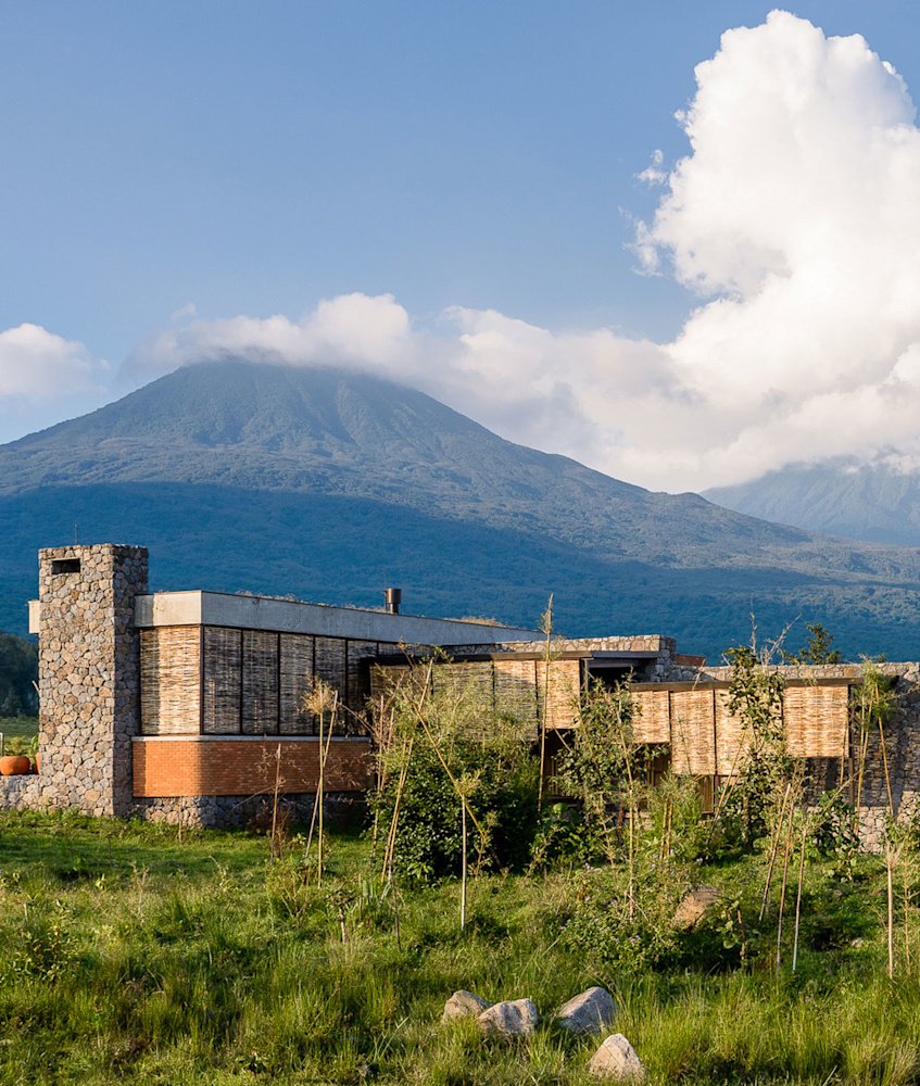 Singita Kwitonda Lodge with the Virunga volcanoes behind